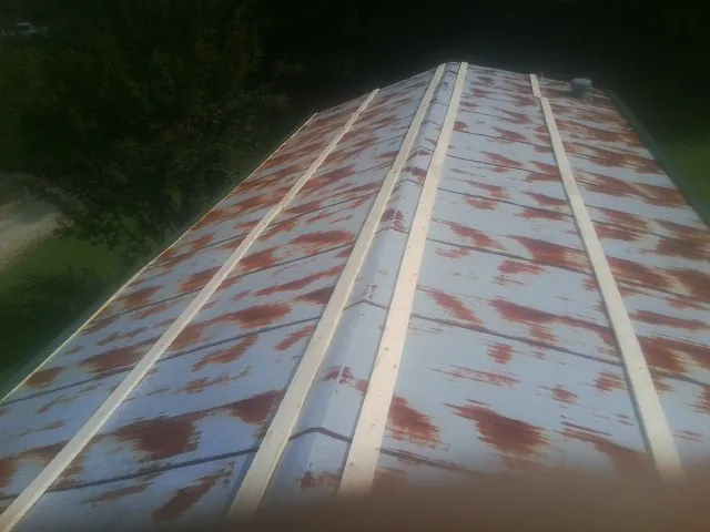 Rusted metal roof panels with new wood purlins before replacement — Storm Damage Roof Repair in Bernalillo by Roofing Brothers